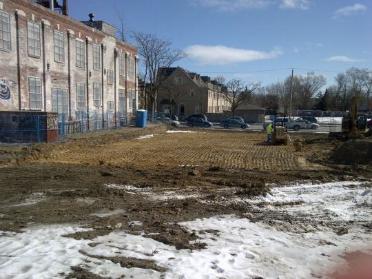 Heavy equipment grading the exposed ground at the town square site